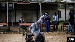 Un agent de la Commission électorale du Malawi assis sur un groupe électrogène, à Blantyre, 20 mai 2014.