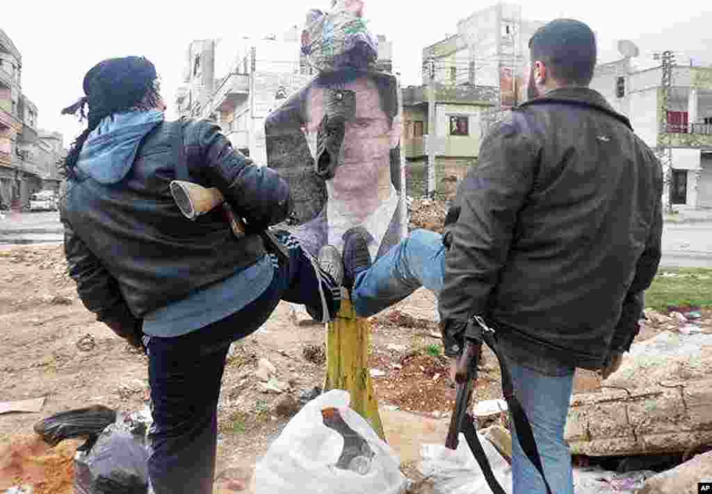 This citizen journalism image shows Syrian rebels stomping on a portrait of anti-Syrian Syrian President Bashar al-Assad in Idlib. (AP/Local Coordination Committees in Syria) 
