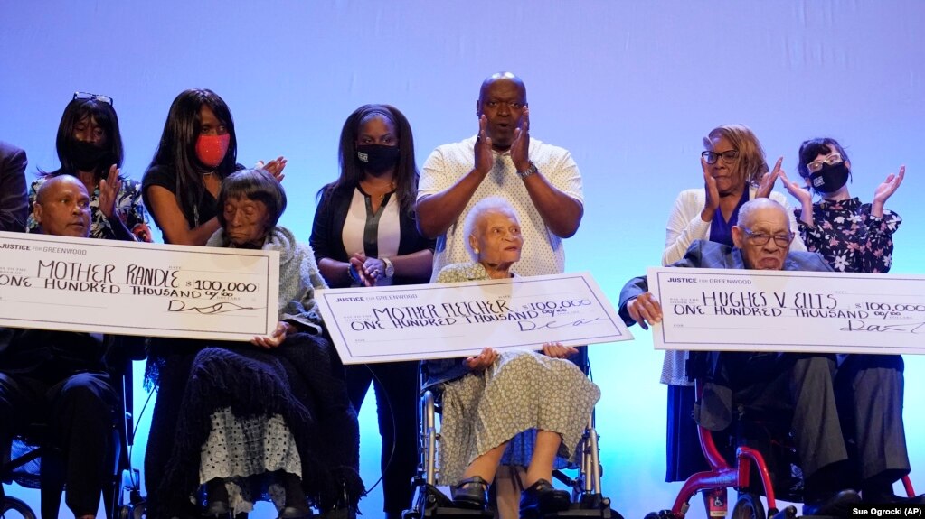 塔尔萨种族屠杀幸存者莱西·本宁菲尔德·兰德尔(左起第二个)、维奥拉·弗莱彻(中)和休斯·范埃利斯(右)收到来自“格林伍德正义”组织的10万美元支票。（2021年5月29日）(photo:VOA)