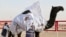 Sudanese camel keepers crown a victorious contestant at Al Dhafra Festival in Liwa desert area 120 kilometres (75 miles) southwest of Abu Dhabi, United Arab Emirates, Dec. 22, 2021. 