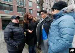 Residents of a HUD Section 8 apartment complex discuss financial issues and the impact the government shutdown during a meeting outside their building, Jan. 18, 2019, on Roosevelt Island in New York.