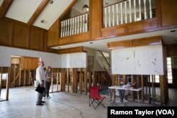 Rob Hellyer, owner of Premier Remodeling & Construction, evaluates reconstruction progress inside Kathryn Clark’s two-story home.