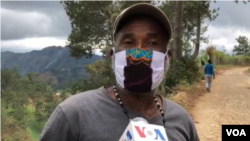This Furcy resident, wearing a patchwork face mask, says locals make sunflower tea to soothe cold and flu-like symptoms. (Photo: Matiado vilme / VOA) 