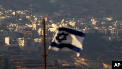 FILE - An Israeli flag flies near the village of Majdal Shams in the Israeli-controlled Golan Heights, Oct. 11, 2018.