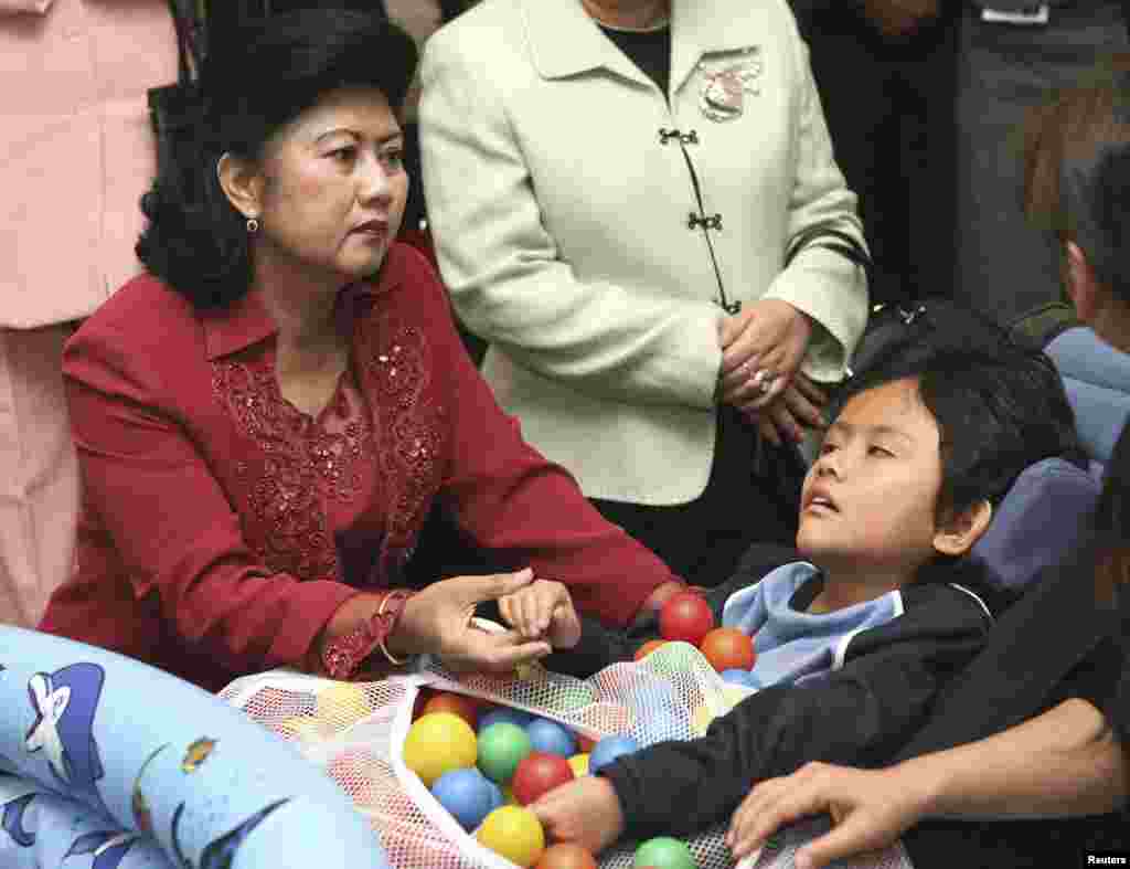 Ibu Ani Yudhoyono mengunjungi seorang anak di Sekolah Tokyo Metropolitan Kita di Tokyo, 28 November 2006. (Foto: Reuters)