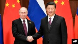 시진핑 중국 국가 주석(오른쪽)과 블라디미르 푸틴 러시아 대통령이 26일 중국 베이징에서 만나 정상회담을 했다. 