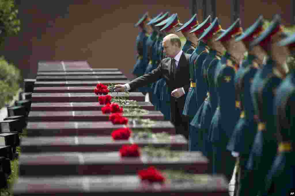 Russian President Vladimir Putin, center, takes part in a wreath-laying ceremony at the Tomb of the Unknown Soldier outside Moscow&#39;s Kremlin Wall.