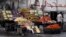 File - A vendor stands next to his fruit stall as he waits for customers near a mosque in Cairo.