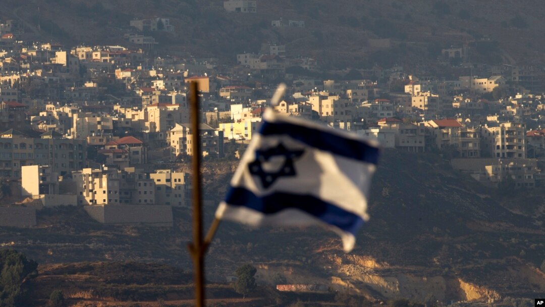 FILE - An Israeli flag flies near the village of Majdal Shams in the Israeli-controlled Golan Heights, Oct. 11, 2018.