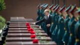 Russian President Vladimir Putin, center, takes part in a wreath-laying ceremony at the Tomb of the Unknown Soldier outside Moscow&#39;s Kremlin Wall.