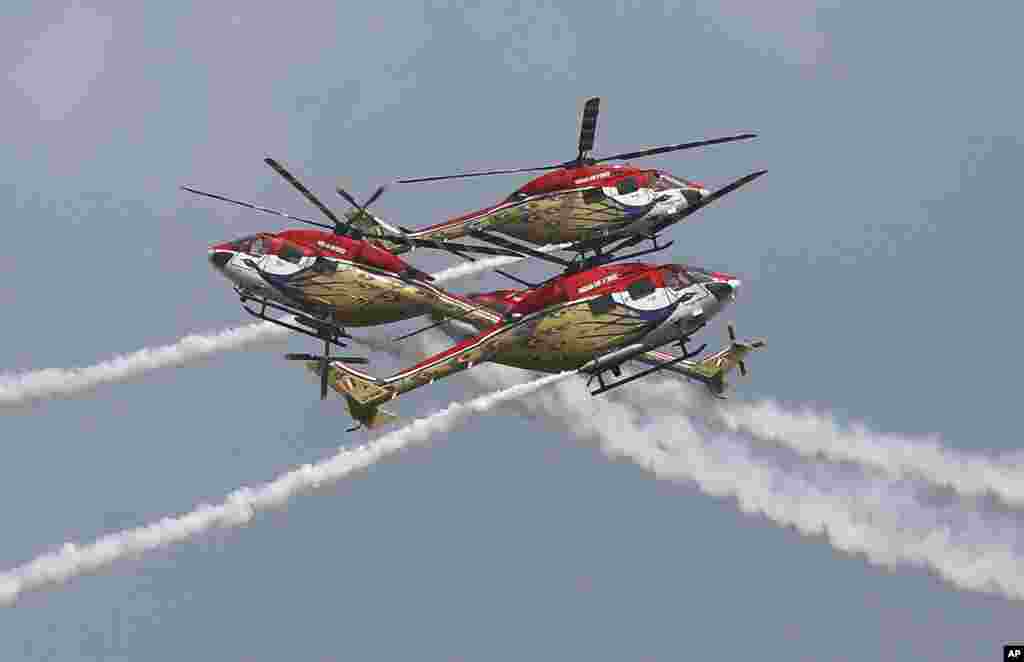 Sarang, a helicopter display team of Indian Air Force, performs aerobatic maneuvers on the inaugural day of Aero India 2021 at Yelahanka air base in Bengaluru.