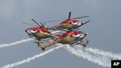 Sarang, a helicopter display team of Indian Air Force, performs aerobatic maneuvers on the inaugural day of Aero India 2021 at Yelahanka air base in Bengaluru.