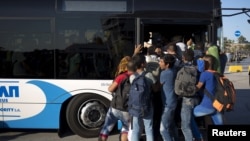 مهاجران سعی می کنند سوار یک اتوبوس در یونان شوند