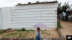 가자지구 북부 지역에 거주하는 팔레스타인 소녀가 집 앞에서 우산을 들고 앉아 있다. 