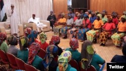 Le président Muhammadu Buhari, à gauche, s'adresse à 82 lycéennes de Chibok libérées par Boko Haram, Abuja, Nigeria, le 7 mai 2017. 