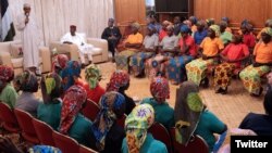 El presidente nigeriano Muhammadu Buhari (izquierda) habla a las 82 escolares Chibok liberadas por Boko Haram y llevadas a Abuja, Nigeria, el 7 de mayo.