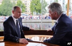 Finnish President Sauli Niinisto, right, and Russian President Vladimir Putin chat as they enjoy a steam boat cruise in Savonlinna, Eastern Finland, on July 27, 2017.
