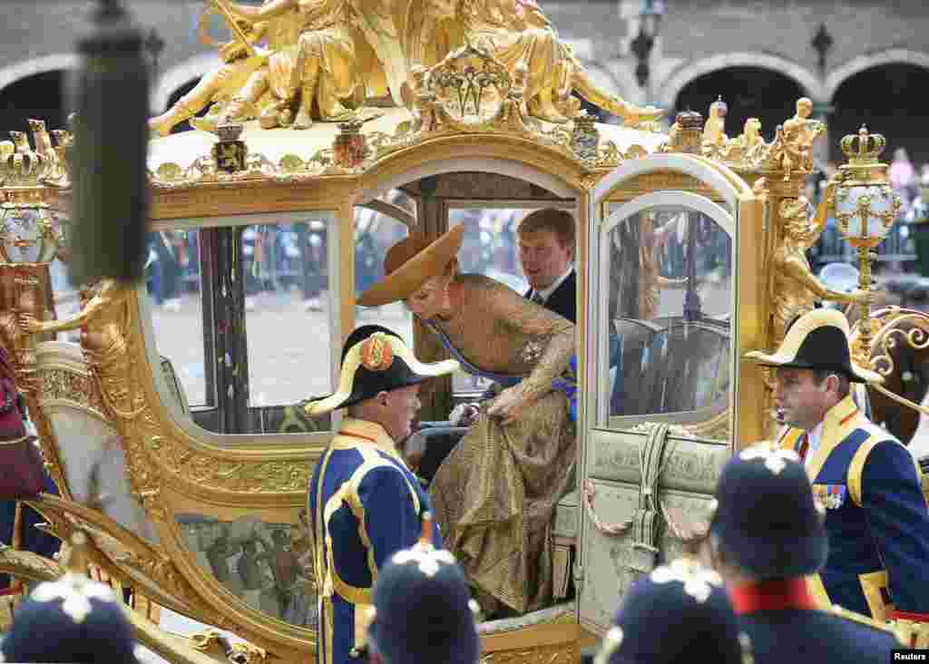 King Willem-Alexander and Queen Maxima arrive at the 13th century &quot;Hall of Knights&quot; in a horse-drawn carriage to officially open the new parliamentary year with a speech outlining the caretaker government&#39;s plan and budget policies for 2014, in The Hague, Netherlands.