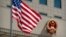 FILE - The American flag flies near the national emblem of China outside of the Bayi Building in Beijing, June 27, 2018. 