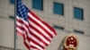 FILE - The American flag flies near the national emblem of China outside of the Bayi Building in Beijing, June 27, 2018. 