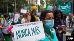 Una mujer sostiene un cartel que reza "mujeres en lucha, nunca más", en referencia a los abortos clandestinos, durante una manifestación por la despenalización del aborto durante el Día Mundial de Acción por el Aborto Legal y Seguro en América Latina, en Caracas.