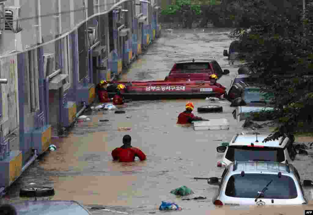 Rescue workers are seen in a parking lot and lower sections of apartment buildings flooded due to heavy rain in Daejeon, South Korea.