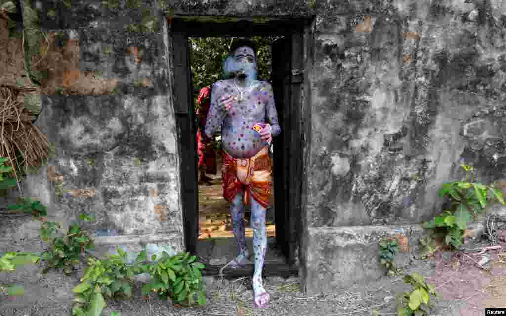 A devotee with his body painted arrives to perform during a ritual as part of the annual Shiva Gajan religious festival at Sona Palasi village, in West Bengal, India.