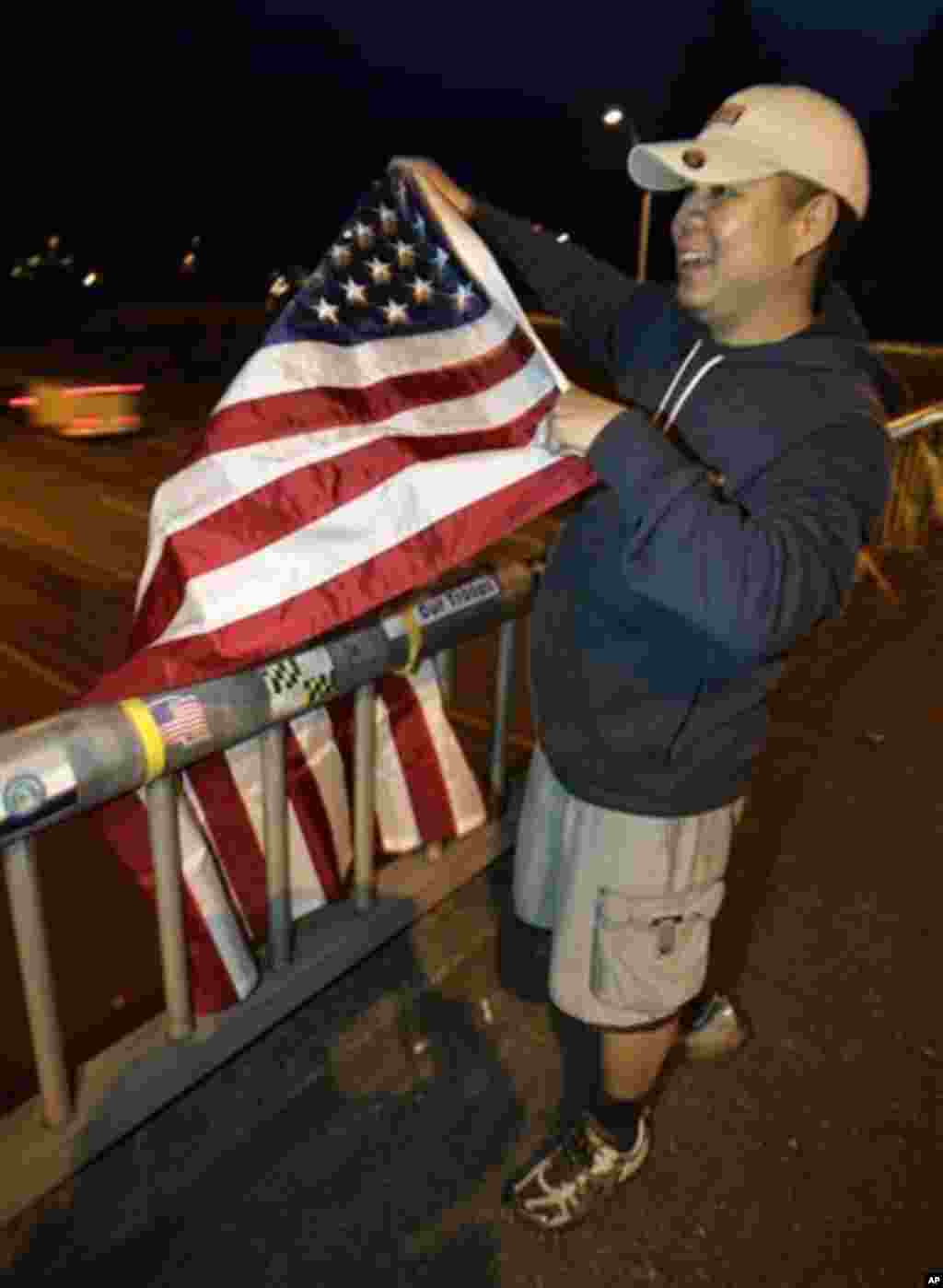 U.S. Army Staff Sgt. Lemuel Nacionales, cheers and waves a U.S. flag on the "Freedom Bridge" just outside Joint Base Lewis-McChord, Sunday, May 1, 2011, near Tacoma, Wash., after he heard the news that Osama Bin Laden had been killed (AP)