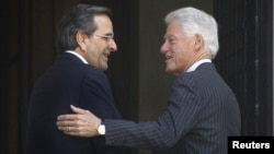 Greek Prime Minister Antonis Samaras (L) welcomes visiting former U.S. President Bill Clinton during their meeting in Athens July 22, 2012. 