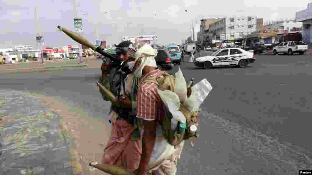 Pria milisi mengamankan sebuah jalanan menuju bandara dalam bentrokan di kota pelabuhan Yaman, Aden.