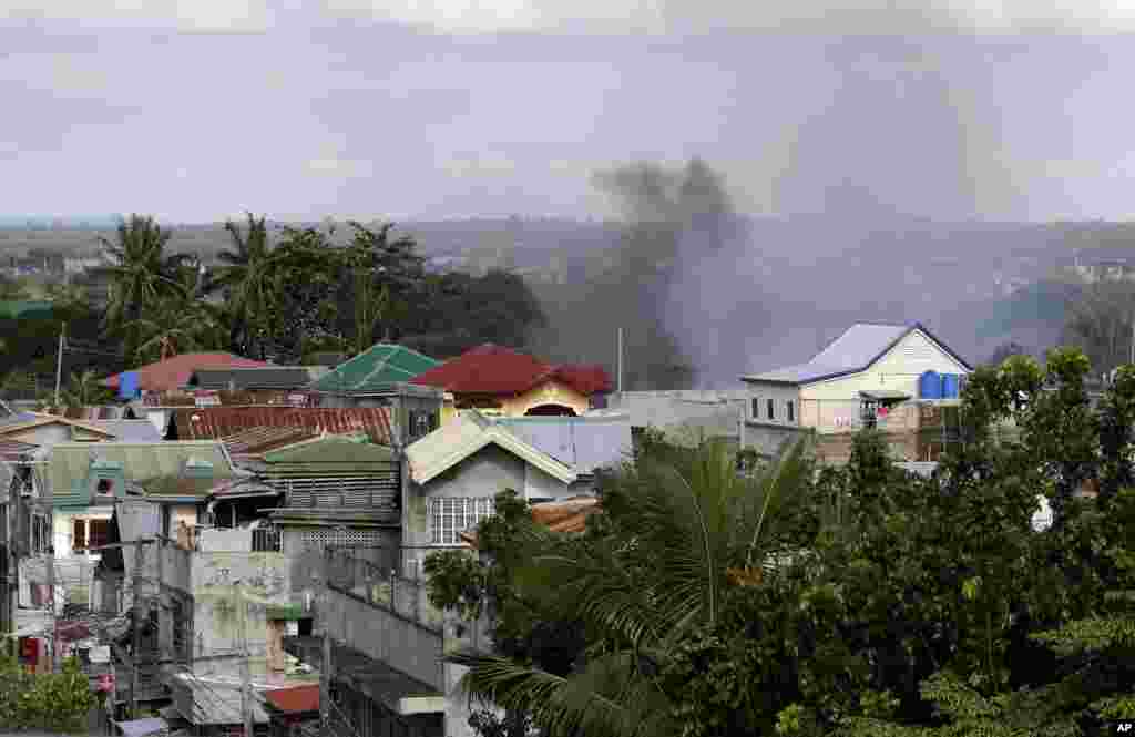 Smoke rises from a neighborhood where Muslim rebels are holding scores of hostages as human shields in Zamboanga, Philippines, Sept. 10, 2013.