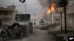 FILE - A car bomb explodes next to Iraqi special forces armored vehicles as they advance toward Islamic State held territory in Mosul, Iraq, Nov. 16, 2016. 