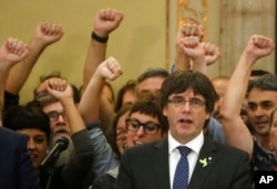 Catalan President Carles Puigdemont sings the Catalan anthem inside the parliament after a vote on independence in Barcelona, Spain, Oct. 27, 2017.