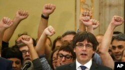 FILE - Catalan President Carles Puigdemont sings the Catalan anthem inside the parliament after a vote on independence in Barcelona, Spain, Oct. 27, 2017.