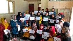 Afghan women chant and hold signs of protest, in Kabul, Dec. 27, 2021. Around 20 members of Afghanistan Women's Political Participation Network protested in a closed area in Kabul while holding signs asking the Taliban for equality.