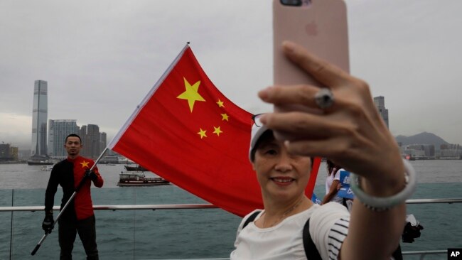 资料照:在香港的中国支持者展示中国国旗并自拍。(2019年8月17日)