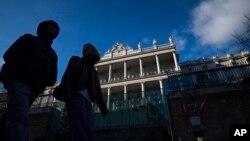 People walk past Palais Coburg, where closed-door nuclear talks take place in Vienna, Austria, Dec. 17, 2021.