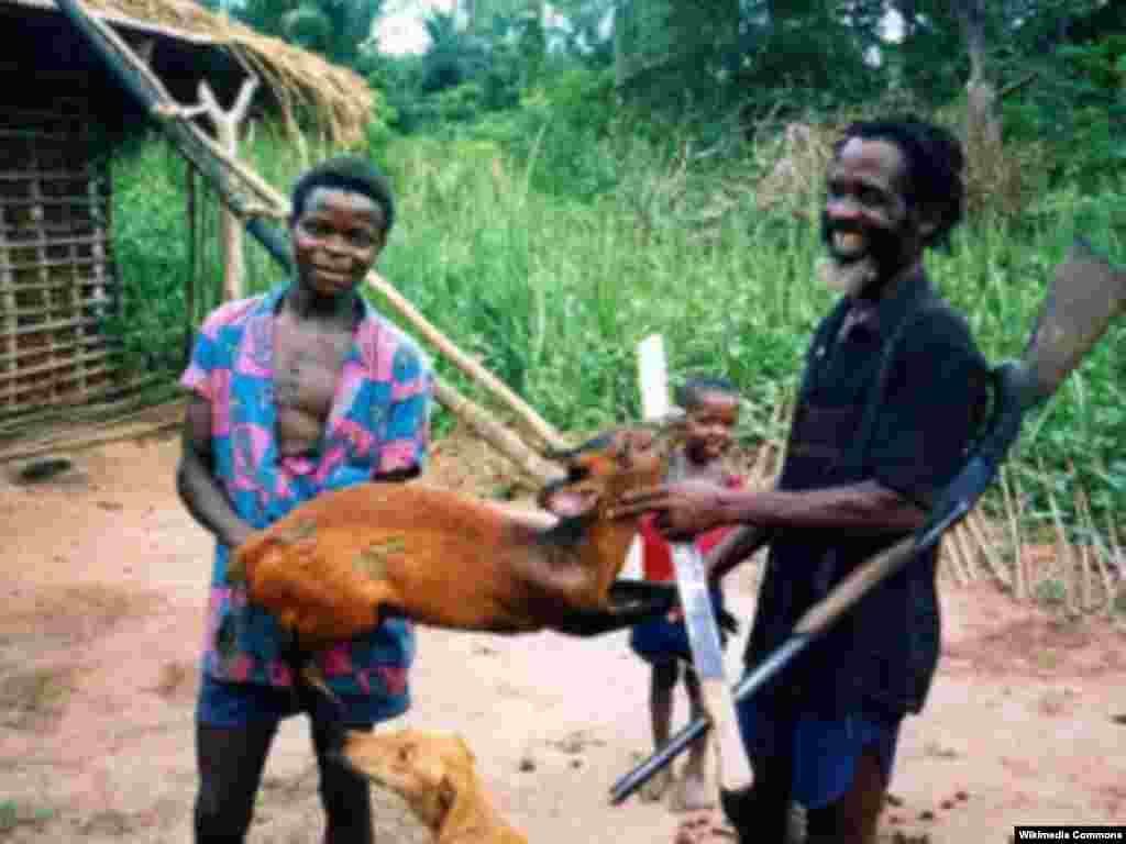 Un chasseur troque l&rsquo;antilope qu&rsquo;il a tuée, avec d&rsquo;un habitant d&rsquo;un village africain. 