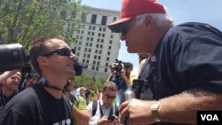 A Trump supporter and a Trump opponent square off outside the Republican National Convention in Cleveland, Ohio, July 20, 2016. (W. Gallo/VOA)