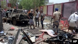 Fighters loyal to the government gather at the site of a suicide car bombing in Yemen’s southern city of Aden, Yemen, Aug. 29, 2016. The bombing claimed by the Islamic State group in Aden has killed over 50 pro-government troops.