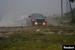 Una camioneta avanza sobre una carretera inundada cuando el huracán Michael avanza por Alligator Point, en Florida. Octubre 10 de 2018. Reuters/Carlo Allegri.