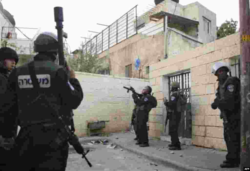 Israeli riot police shoot tear gas at Palestinian youth, not seen, during a protest against Jewish settlements in the east Jerusalem neighborhood of Silwan, Monday, Dec. 27, 2010. Tensions regularly run high in Silwan, where a small group of Israeli settl