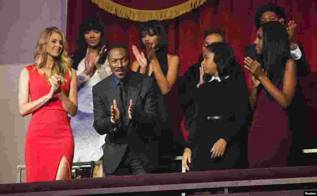 Eddie Murphy, his partner Paige Butcher (L) and members of his family applaud as he takes his seat for the Mark Twain prize for Humor honoring him at the Kennedy Center in Washington, Oct. 18, 2015.