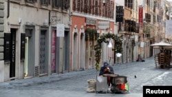 A street vendor sells roasted chestnuts on Via Frattina, as Italy goes back to a complete lockdown during Christmas season as part of efforts put in place to curb the spread of the coronavirus disease (COVID-19), in Rome, Italy, December 24, 2020. 
