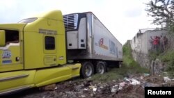 A truck leaves with an abandoned trailer full of bodies that has been parked in Tlajomulco de Zuniga, Jalisco, Mexico ,Sept. 15, 2018 in this image taken from video.
