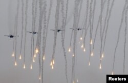 FILE - Jet fighters release flares during the Zapad 2017 war games at a range near the town of Borisov, Belarus, Sept. 20, 2017.