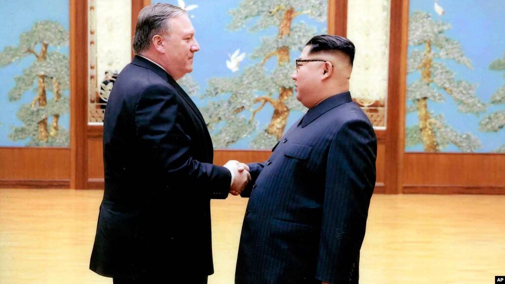 En esta imagen divulgada por la Casa Blanca, el secretario de Estado, Mike Pompeo saluda a Kim Jong Un durante su primera visita a Corea del Norte.