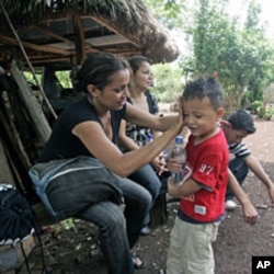 A migrant from Honduras wipes her son's face during a rest stop on the seven hour journey through the Peten Jungle in northern Guatemala (File)