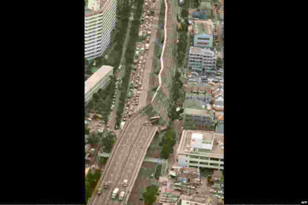 A portion of the Hanshin Expressway is twisted down on its side in Nishinomiya after a powerful earthquake in the western Japanese on Jan. 17, 1995. Last Jan. 17, a half hour before dawn, a fault line under the port of Kobe snapped, and a sleeping city aw