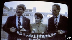 资料照：电视画面显示，来自加州的民主党众议员南希·佩洛西(中)、来自乔治亚州的民主党众议员本·琼斯(左)和来自华盛顿州的共和党众议员约翰·米勒在天安门广场展示横幅，向为中国民主事业牺牲的烈士致敬。(1991年9月4日)
